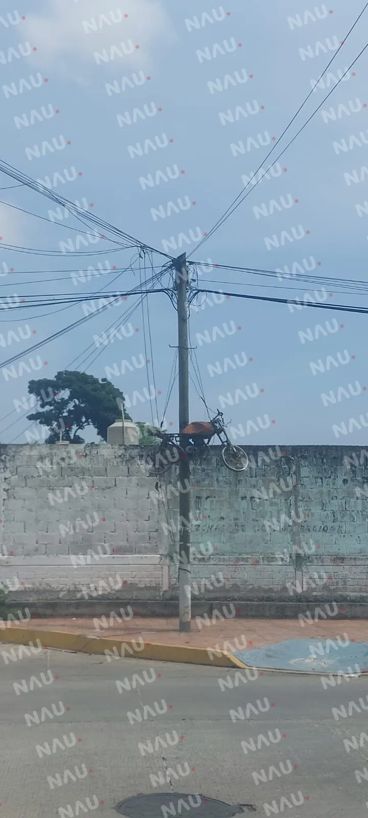 Dejan motocicleta calcinada amarrada a un poste de Teléfonos de México