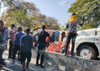 Traileros, conductores de unidades de pasaje obligan a migrantes a desbloquear la carretera costera.